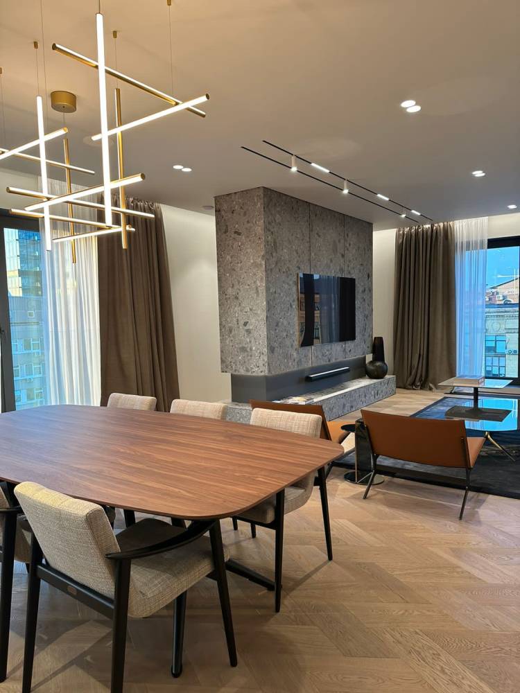 Tavolo Cattelan, sedie Minotti, poltrona e tavolino Poliform, illuminazione Flos